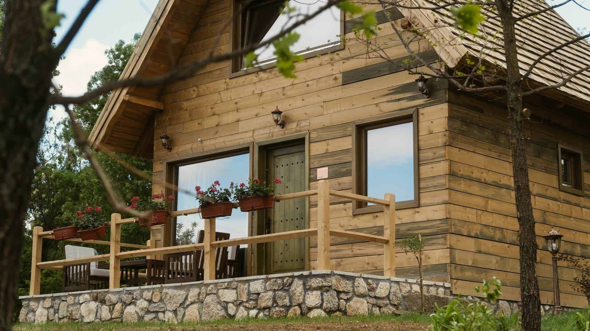 Drvena brvnara sa terasom i cvećem u zaseoku Brana